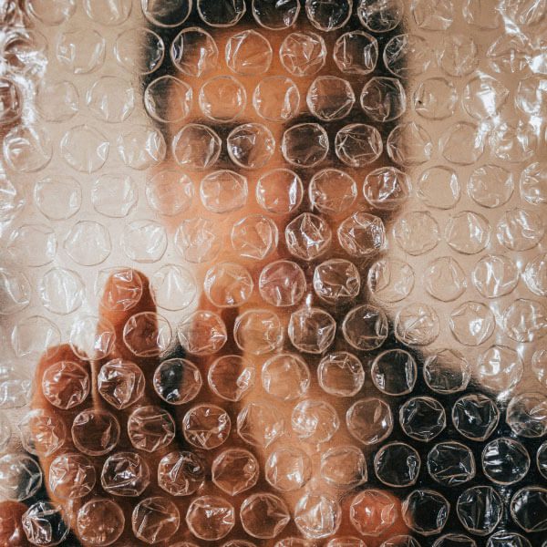 A person's face is behind bubble wrap
